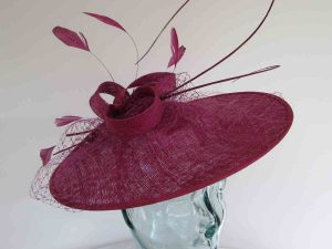 Circular hatinator with sinamay bow in berry