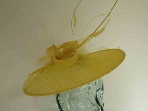 Circular hatinator with sinamay bow in daffodil yellow