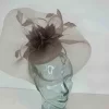 Pillbox with crin and feathered flower in coffee