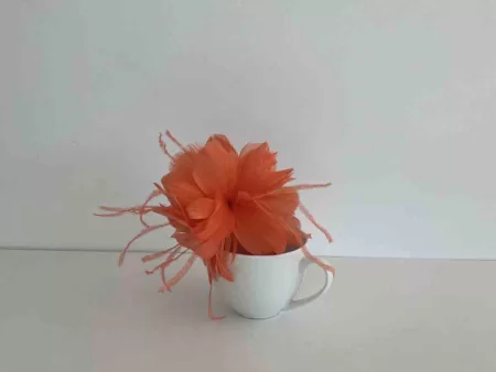 Feathered flower fascinator in persimmon